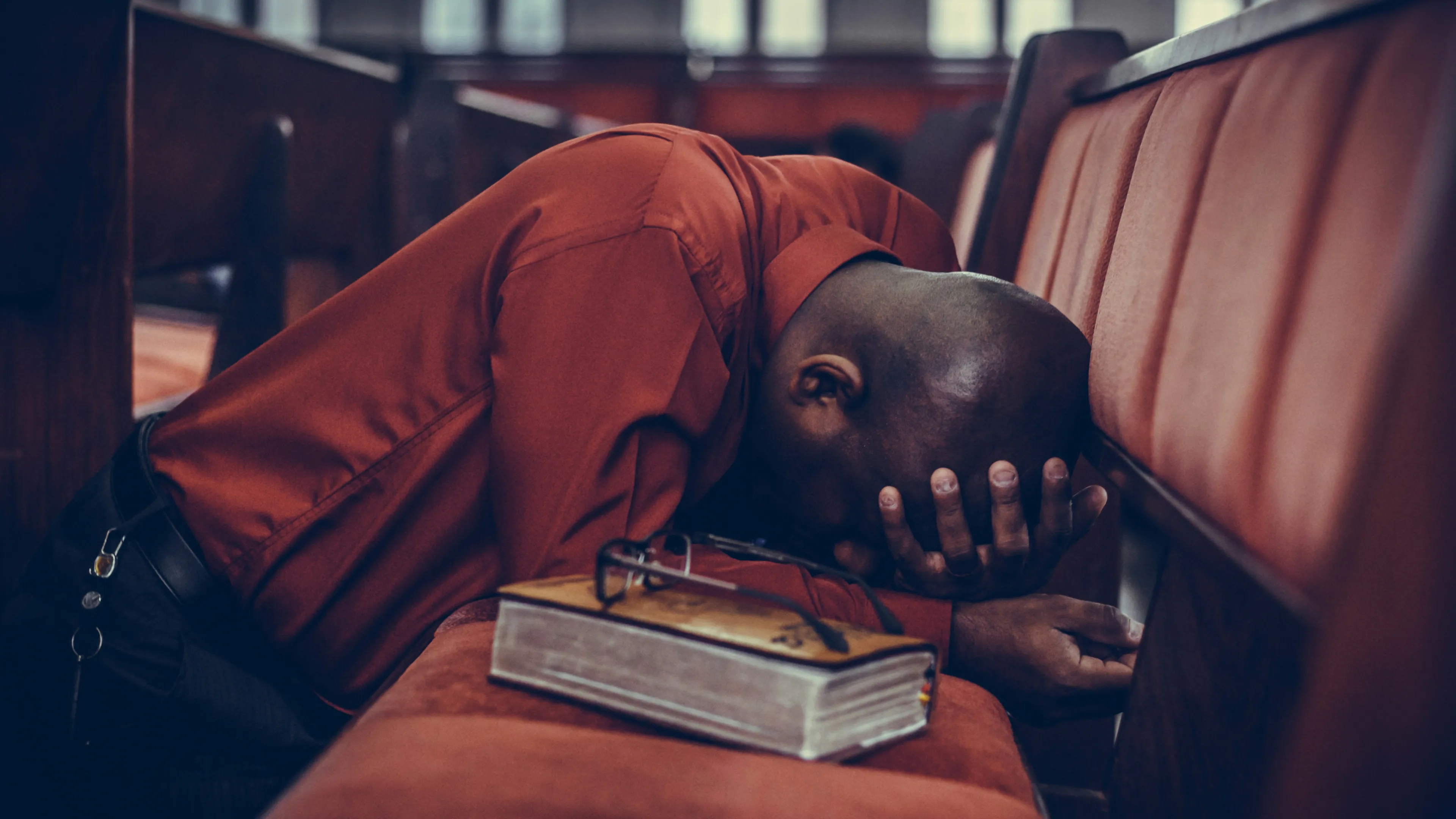 A man with his head down in prayer.