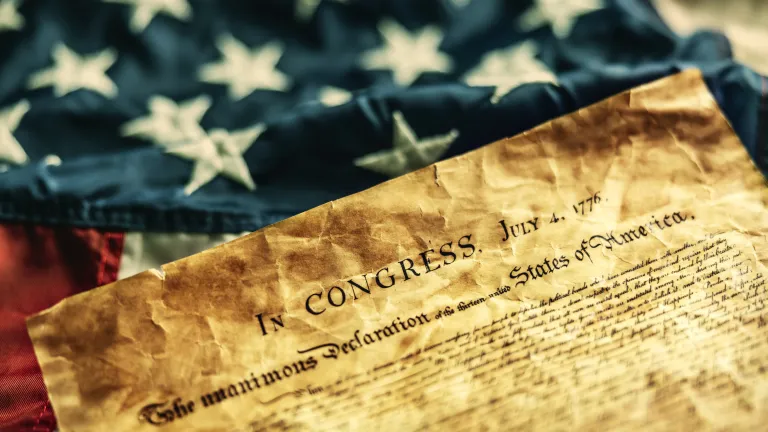 The Declaration of Independence on top of a US flag.